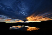 Formations nuageuse se reflétant sur un plan d'eau au coucher du soleil, Brognard, France