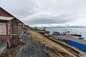 Buildings, loading docks, and cargo ships on Barentsburg's coast. Barentsburg, Spitsbergen Island, Svalbard, Norway.