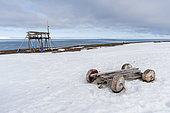A hunting stand and wood wheeled cart on a snowy beach at Mushamna. Spitsbergen Island, Svalbard, Norway.