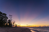 Rays of sunlight over a sandy tropical beach at sunset. Denis Island, The Republic of the Seychelles.