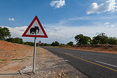 A traffic warning sign designating an African elephant crossing, on the road to Chobe National Park. Chobe National Park, Botswana.