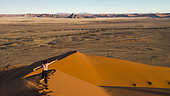 Young girl running on a sand dune, Sossusvlei Dunes - Namib-Naukluft National Desert, Namibia