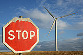 Stop sign in front of a wind turbine which could illustrate the mistrust and the growing refusal of this green and renewable energy but which disfigures the landscape, Haute Marne, France