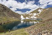 Hikers in front of the Estany Blau and the Cometa peak from Spain, Bouillouses site, Pyrénées-Orientales, Montagnes Catalanes, France
