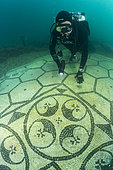 Scuba diver exploring a splendid mosaic (tessellatum) in black and white decorated with a pattern of hexagons, perfectly preserved, Villa a Protiro, Marine Protected Area of Baia, Naples, Italy, Tyrrhenian Sea