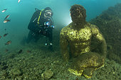 Scuba diver with statue depicting a companion of Ulysses (perhaps Baio), located in the submerged Nymphaeum of Emperor Claudius, near Punta Epitaffio , Marine Protected Area of Baia, Naples, Italy, Tyrrhenian Sea