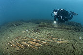 Scuba diver observing a floor covered with terracotta boards situated in the thermal complex of Lacus Baianus, Marine Protected Area of Baia, Naples, Italy, Tyrrhenian Sea