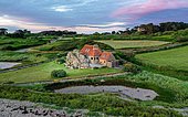Drone shot of a farmhouse on granite cliffs on the coast of Plougrescant, Côtes-d'Armor department, Brittany, France, Europe