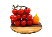 Several red and yellow ripe tomatoes on a cutting board on a light background. Natural product. Natural color. Close-up.