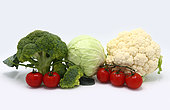 Head of cabbage, inflorescences of broccoli and cauliflower and red ripe tomatoes on a light background. Natural product. Natural hue. Close-up.