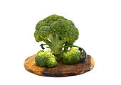 Raw broccoli inflorescence on a cutting board on a light background. Natural product. Natural hue. Close-up. [dump] =>