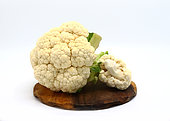 Raw cauliflower on a cutting board on a light background. Natura product. Natural hue. Close-up.
