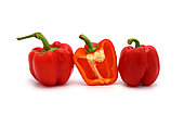 Two red ripe sweet peppers and one pepper in a cut on a light background. Natural product. Natural color. Close-up.