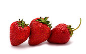Three ripe strawberries on a light background. Natural color and shape. Close-up.