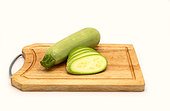 Whole and cut zucchini on a cutting board on a light background. Natural product. Natural color. Close-up.