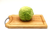 Head of cabbage on a wooden cutting board on a light background. Natural product. Natural color. Close-up.