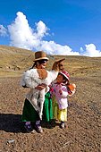 Aymara children carrying a young llama near Lake Titicaca, Bolivia