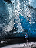Glacial cave in Vatnajoekull Nationalpark, Iceland. Glacial cave in the Breidamerkurjoekull Glacier in Vatnajoekull National Park. Light shines through a moulin on a climber. europe, northern europe, iceland, February