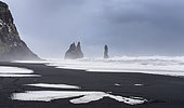 Plage de sable volcanique noir de Reynisfjara avec les stacks de Reynisdrangar. Côte de l'Atlantique Nord près de Vik y Myrdal en hiver, Terre du Sud, Islande.