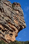 Hermitage of San Cristobal walled into the wall (mimetic with the rock), located at the base of the rocky peak, Aragon, Spain.