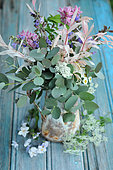 Blue Bouquet: Bouquet with foliage of Eucalyptus, Weigelia, Chamomile, Sage in a blue enamelled iron pot on a blue wooden table