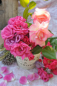 Bouquets of roses. Emera roses and other varieties in bouquets, petals, enamelled iron pot marked 'garden'.