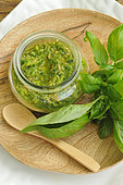 Pesto, Basil (Ocimum basilicum), Basil in cooking, pesto on a wooden dish, fresh basil leaves