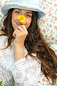 Calendula flowers (Calendula officinalis), virtues of Calendula, young woman in the garden, relaxing moment