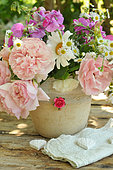 Bouquet of garden flowers: daisies, roses, sweet peas, asters, hearts and lace for decoration