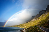 A rainbow and storm over the Kogelberg Mountains along the coastline from Clarence Drive between Gordon's Bay and Rooi-Els on the eastern part of False Bay, Cape Town, Western Cape, South Africa.