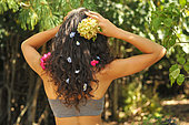 Young woman with flowers in her hair in a garden, nature, living in harmony in the garden