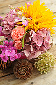 Bunch of yellow and pink flowers, Perennial sunflower (Helianthus x multiflorus), Sweet pea (Lathyrus odoratus), Hydrangea (Hydrangea sp), Rose (Rosa sp) and Cedar cones