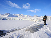 Armed Arctic Guide. Glacier front of Fridtjovbreen and the frozen fjord Van Mijenfjorden. Landscape in Van Mijenfjorden National Park, (former Nordenskioeld NP), Island of Spitsbergen, part of Svalbard archipelago.