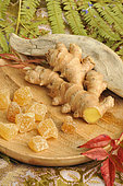 Ginger rhizome (Zingiber officinale) and candied fruit in a wooden plate