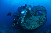 Rebreather divers on the 40MM anti-aircraft machine gun on SS Thistlegorm wreck a British cargo steamship built in North East England in 1940 and sunk by German bomber aircraft in 1941. Near Ras Mohammed, Sinai Peninsula, Red Sea, Egypt