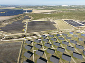 Rows of solar panels at a photovoltaic plant and the town of Espejo in the background. Aerial view. Drone shot. Córdoba province, Andalucía, Spain.