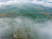 Windmills on a wind farm near Zahara de los Atunes. At a cloudy morning. Aerial view. Drone shot. Cádiz province, Andalusia, Spain.