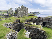 Jarlshof, site archéologique des îles Shetland, qui a été habité du néolithique au Moyen-Âge. Timoneries datant de l'âge du fer, en arrière-plan la vieille maison du Moyen-Âge et le phare de Sumburgh Head, Shetland, îles du Nord, Écosse, Grande-Bretagne, Royaume-Uni