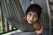 Nicaragua, San Juan de Nicaragua. Portrait of a 7-year-old Rama girl in a hammock living along the Rio Indio river.