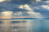 Tyndall effect over Lake Constance, sun rays break through cloudy sky and reflect on the water, Canton Thrugau, Switzerland, Europe