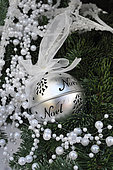 Christmas ball with ribbon, festive decoration, tree and pearl garland