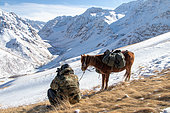 Reserve guard observing the landscape through binoculars, Syrt, Kyrgyzstan