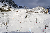 Sunny ski slope with skier and ski lift at ski resort in Alps mountains, Pralognan la Vanoise, France.
