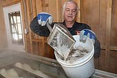 Foam containing impurities is removed from the top of the water during cooking, Making maple syrup in a sugar shack at sugar time, Saint-Barthélemy, Lanaudière, Quebec, Canada