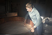 France, Haute-Savoie, La Clusaz, 2023-03-26. Young woman farmer, sister of Lucas, making curd by inserting rennet into cow's milk to produce reblochon. EDITORIAL ONLY. Photograph by Antoine Boureau.