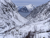 Valley of Botnelva and mountain road Kaperdalsveien, in the background Sifjorden. The island Senja during winter in the north of Norway. Europe, Norway, Senja, March