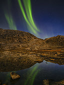 Aurore boréale se reflétant dans un étang lors de la pleine lune, fjord glaciaire de Sermilik (Sermiligaaq) dans la région d'Ammassalik à l'est du Groenland.