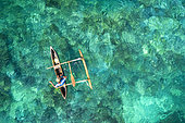 Un pêcheur ave sa pirogue traditionnelle sur le lagon bleu turquoise de Mayotte.
