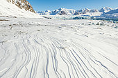 Sastrugi or snow patterns formed by the wind in the bay on 14 July, Krossfjord in Spitsbergen, Svalbard archipelago