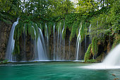 Crystal-clear waterfall in one of the lakes in Plitvice National Park in summer, Croatia